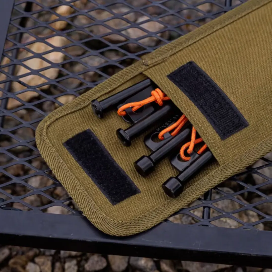 Close-up of heavy-duty steel tent pegs stored in reinforced khaki pouch